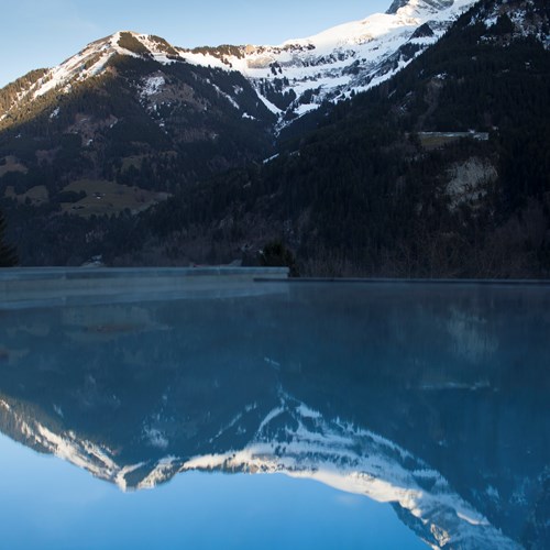 Outdoor pool with mountain views at Hotel National in Champery